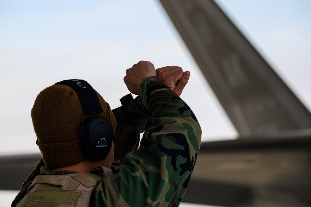 U.S. Air Force Airman 1st Class Bryan Arancibia, 355th Aircraft Maintenance Unit crew chief, marshals an F-35A Lightning II during a mini generation on Eielson Air Force Base, Alaska, Oct. 26, 2022.