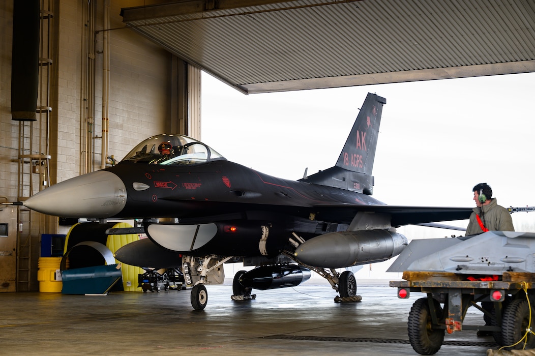 A U.S. Air Force crew chief assigned to the 18th Aircraft Maintenance Unit performs recovery operations on an 18th Aggressor Squadron F-16 Fighting Falcon at Eielson Air Force Base, Alaska, Oct. 29, 2022.