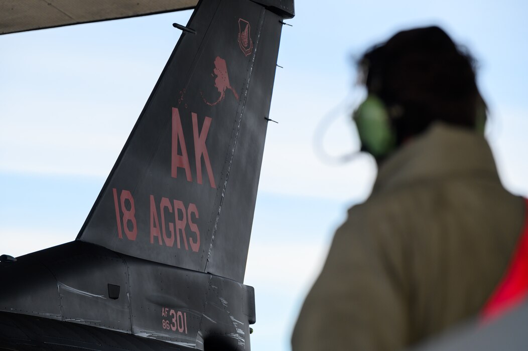 A U.S. Air Force crew chief assigned to the 18th Aircraft Maintenance Unit performs recovery operations on an 18th Aggressor Squadron F-16 Fighting Falcon at Eielson Air Force Base, Alaska, Oct. 29, 2022.