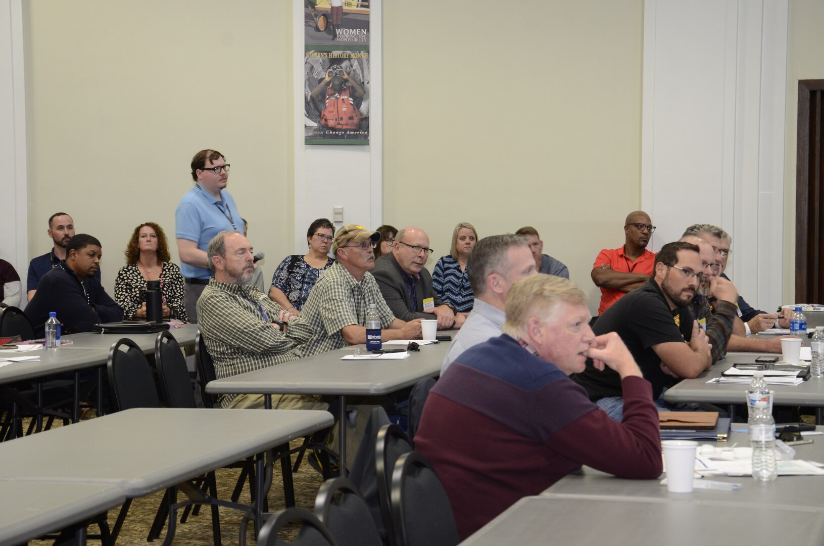 Audience sits as they listen to a briefing.