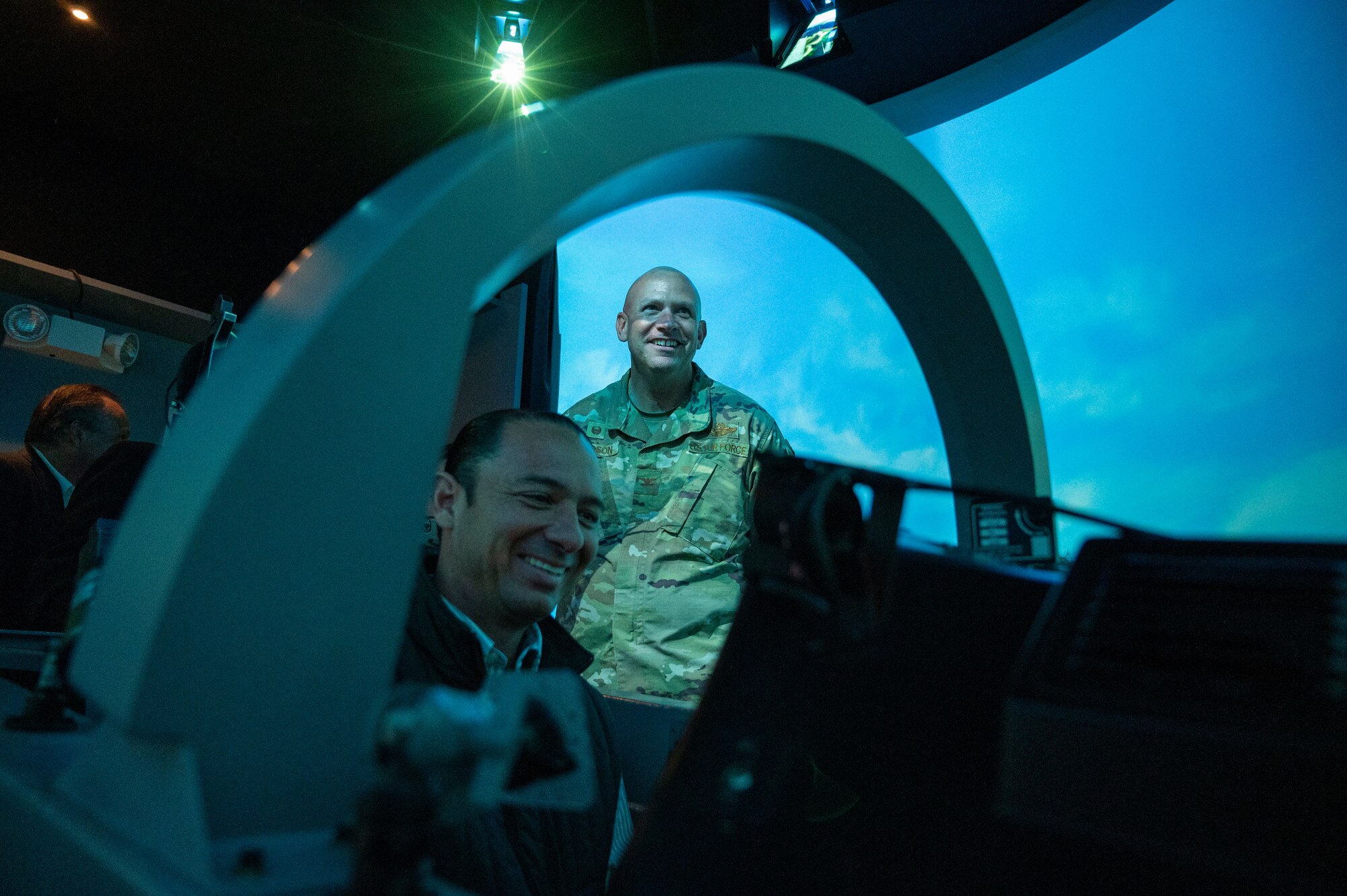 Emilio de Hoyos, Mayor of Ciudad Acuna, sits in the cockpit of a T-6A Texan II simulator while U.S. Air Force Col. Kevin Davidson, 47th Flying Training Wing commander, looks over his shoulder at Laughlin Air Force Base, Texas, Nov. 1, 2022. Laughlin’s mission is to develop U.S. Air Force pilots and the base relies on support from the local community to make that mission a success. Familiarization tours cultivate understating of the wing’s mission and help forge lasting partnerships in the community.  (U.S. Air Force photo by Senior Airman Nicholas Larsen)