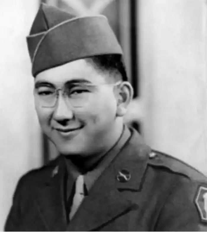 A man in glasses and a cap smiles for a photo.