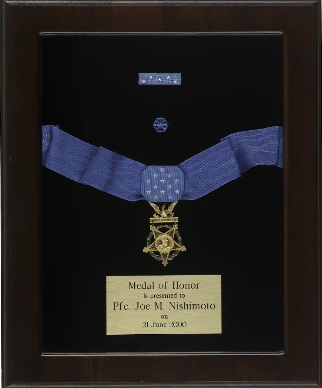 A framed plaque holds a Medal of Honor and a description plate.