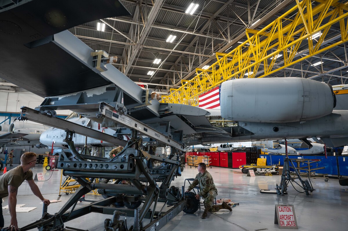 A photo of Airmen replacing an A-10 wing