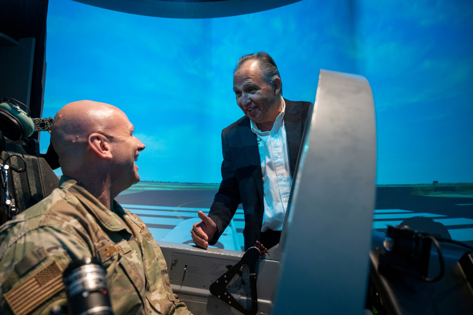 U.S. Air Force Col. Kevin Davidson (left), 47th Flying Training Wing commander, sits in the cockpit of a T-6A Texan II simulator while Al Arreola, Mayor of Del Rio, Texas, jokes about giving flying advice at Laughlin Air Force Base, Texas, Nov. 1, 2022. Laughlin’s mission is to develop U.S. Air Force pilots and the base relies on support from the local community to make that mission a success. Familiarization tours cultivate understating of the wing’s mission and help forge lasting partnerships in the community.  (U.S. Air Force photo by Senior Airman Nicholas Larsen)