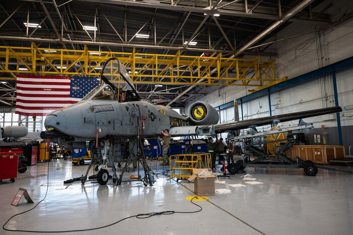 A photo of Airmen replacing an A-10 wing