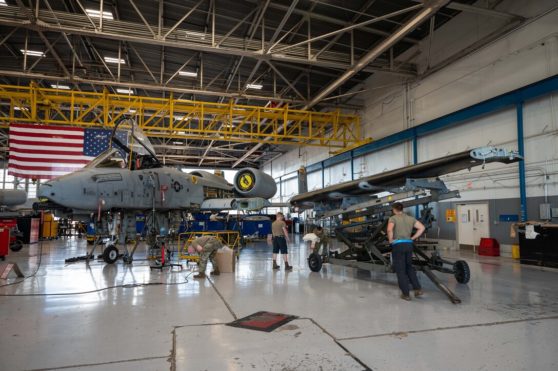 A photo of Airmen replacing an A-10 wing