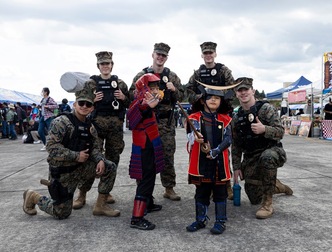 U.S. Marines with Headquarters and Support Company, Combined Arms Training Center Camp Fuji, pose for a group photo with children during the Fuji Friendship Festival at CATC Camp Fuji, Shizuoka, Japan, Oct. 29, 2022. Festival attendees were able to view static displays, listen to live entertainment, and interact with U.S. military and Japan Ground Self-Defense Force personnel. The Fuji Friendship Festival is one of many events Marine Corps Installations Pacific organizes across the Pacific to strengthen the Japan-U.S. alliance and showcase Marine Corps capabilities to host nation residents. (U.S. Marine Corps photo by Lance Cpl. Thomas Sheng)