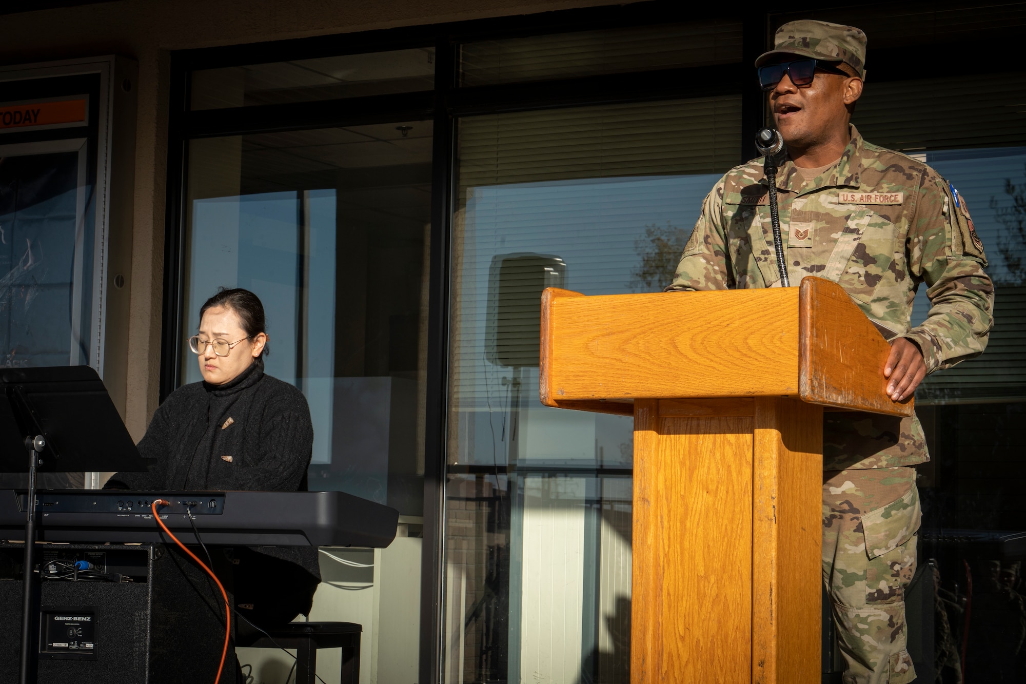 Man singing while a woman plays the keyboard