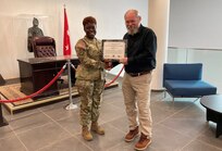 David Pagano, the 405th Army Field Support Brigade’s Logistics Civil Augmentation Program representative for the Wiesbaden area of operations, receives a cross-organizational award signed by U.S. Army Garrison Wiesbaden’s former commander and presented to him by the 405th AFSB commander, Col. Crystal Hills, at the U.S. Army Europe and Africa headquarters, Nov. 4. (Photo by SFC Guido Fermin)