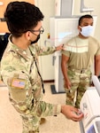 Sgt. Darrell Antonetty-Torres, radiology specialist at Bayne-Jones Army Community Hospital demonstrates performing a shoulder x-ray on fellow radiology specialist Pfc. Cadeau, Jean on Oct. 24 at the Joint Readiness Training Center and Fort Polk, Louisiana.