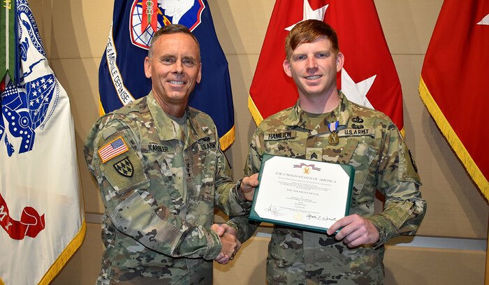 Sgt. John B. Hamilton, 1st Space Battalion, receives the Soldier's Medal, one of the Army’s most distinguished awards for heroism in a non-combat situation, from Lt. Gen. Daniel L. Karbler, commanding general, U.S. Army Space and Missile Defense Command, during a ceremony at Peterson Space Force Base, Colorado, Oct. 18. (U.S. Army photo by Dottie White)