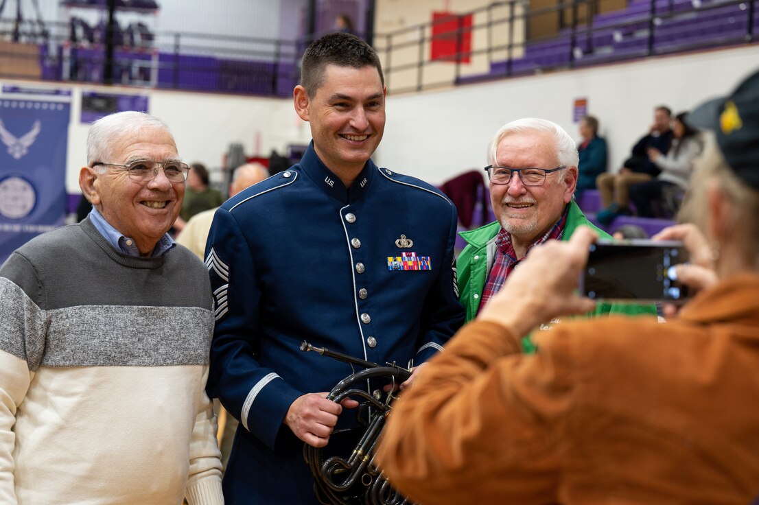 U.S. Air Force Chief Master Sgt. Brett Miller poses for a photo with audience members after The United States Air Force Band’s Fall Tour concert at South Eugene High School, Eugene, Ore., Oct. 26, 2022. Audience members were able to speak with members of The Band one-on-one, test instruments and learn more about The Band’s mission during intermission and before and after each concert. (U.S. Air Force photo by Kristen Wong)