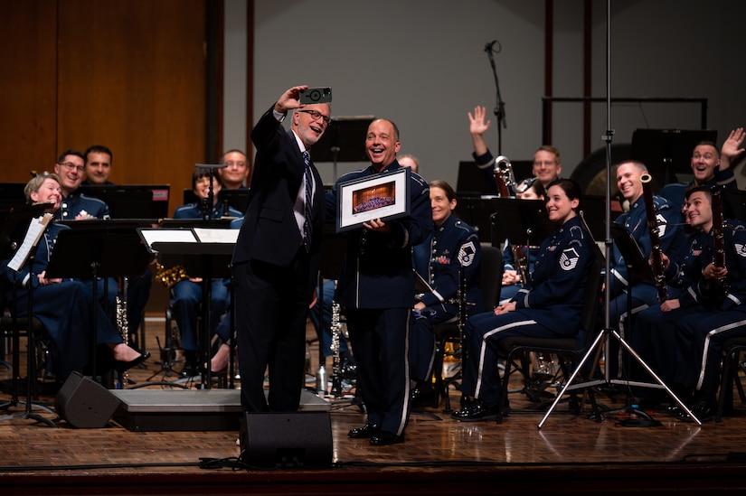 U.S. Air Force Col. Don Schofield poses for a selfie with the president of George Fox University, Robin Baker, after presenting him with a commemorative photo during The United States Air Force Band’s Fall Tour concert at George Fox University, Newberg, Ore., Oct. 25, 2022. The Band’s mission is to honor those who have served, inspire American citizens to heightened patriotism and service, and positively impact the global community on behalf of the U.S. Air Force and the United States of America. (U.S. Air Force photo by Kristen Wong)