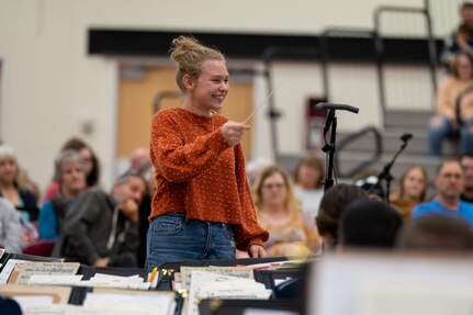 Annison Ballengee, guest conductor, leads The United States Air Force Band’s Concert Band through “Zaparozhski March” at The Band’s Fall Tour concert at Shelton High School, Shelton, Wash., Oct. 23, 2022. Ballengee is the granddaughter of the late U.S. Air Force Chief Master Sgt. Dave Ballengee, former member of The Band and mentor to the current conductor, U.S. Air Force Col. Don Schofield. (U.S. Air Force photo by Kristen Wong)