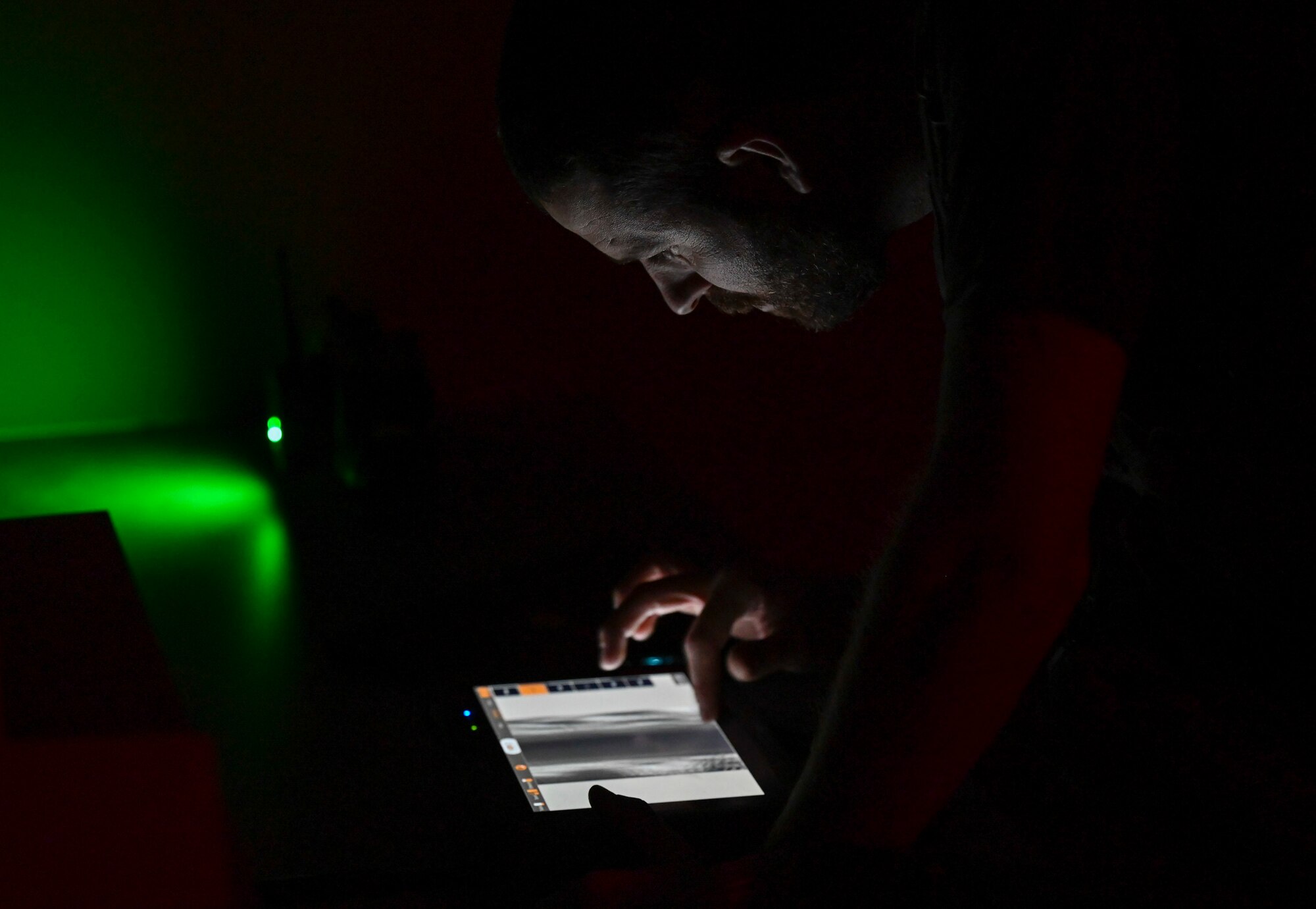 an FBI agent examines an x-ray image of an explosive in a dark room