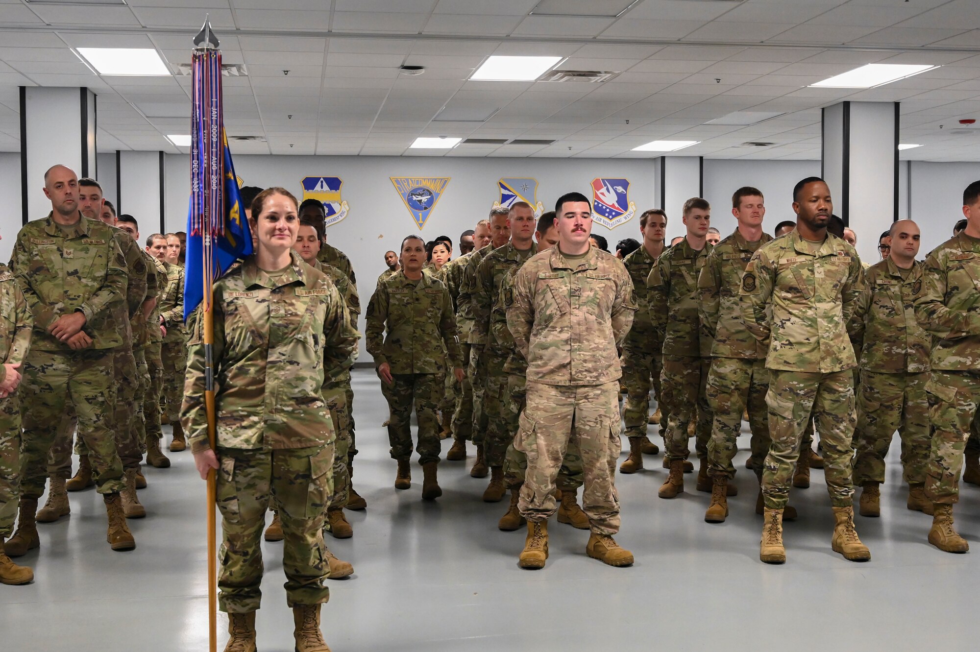 woman holds flag in front of formation of people