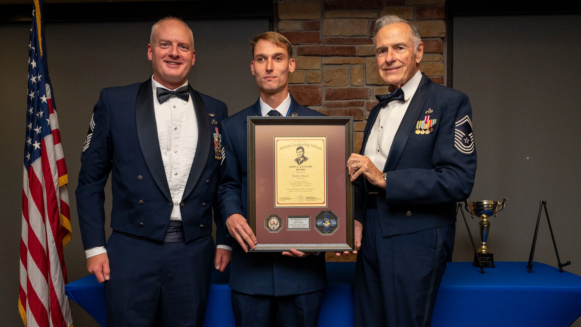 U.S. Air Force Staff Sgt. Matthew Hensel, center, accepts the John L. Levitow Award from U.S. Air Force Chief Master Sgt. Mark Teusch, 49th Component Maintenance Squadron senior enlisted leader, left, and retired U.S. Air Force Chief Master Sgt. Richard McElderry during an Airman Leadership School graduation at Holloman Air Force Base, New Mexico, Nov. 3, 2022.