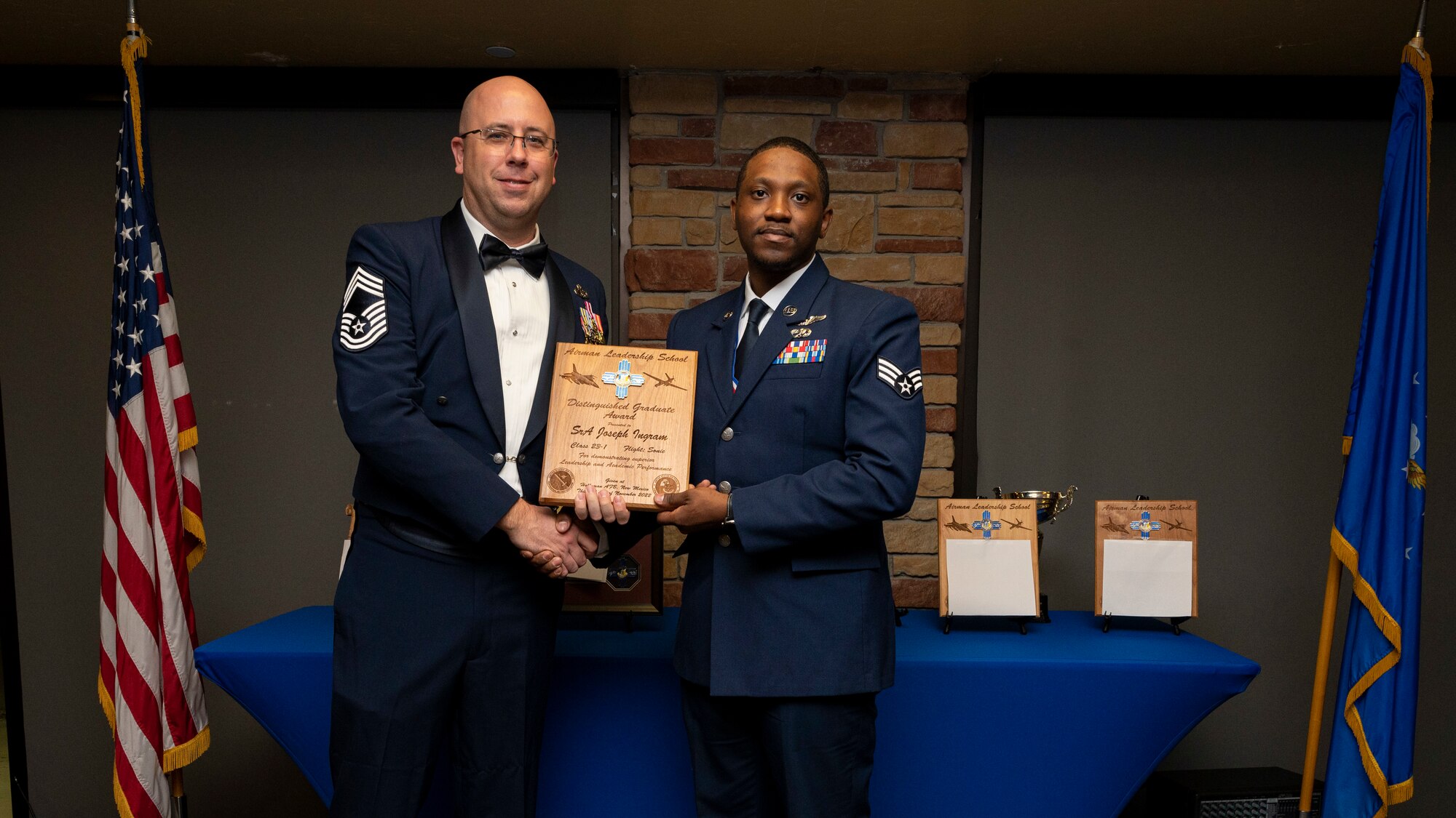 U.S. Air Force Senior Joseph Ingram, right, accepts the Distinguished Graduate Award from Holloman Top III representative Chief Master Sgt. Benjamin Vanderpuy during an Airman Leadership School graduation at Holloman Air Force Base, New Mexico, Nov. 3, 2022.