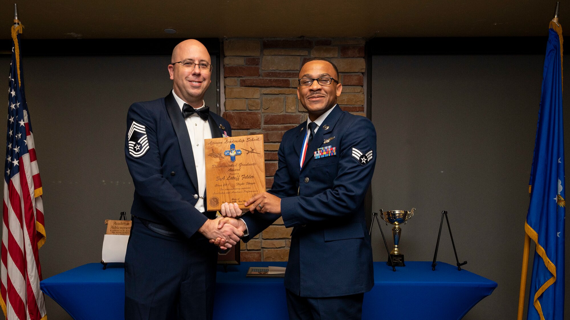 U.S. Air Force Senior Lataff Felder, right, accepts the Distinguished Graduate Award from Holloman Top III representative Chief Master Sgt. Benjamin Vanderpuy during an Airman Leadership School graduation at Holloman Air Force Base, New Mexico, Nov. 3, 2022.