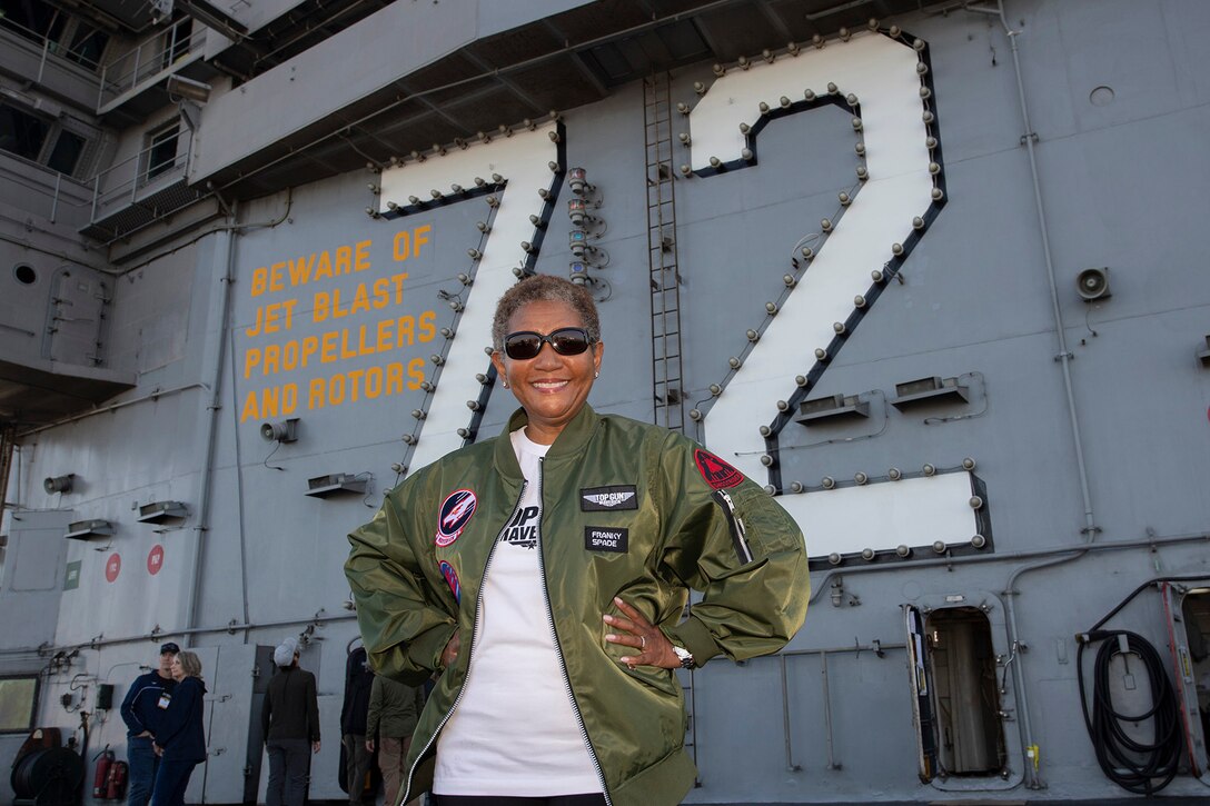 A participants poses in front of the number 72 on the deck of a ship.
