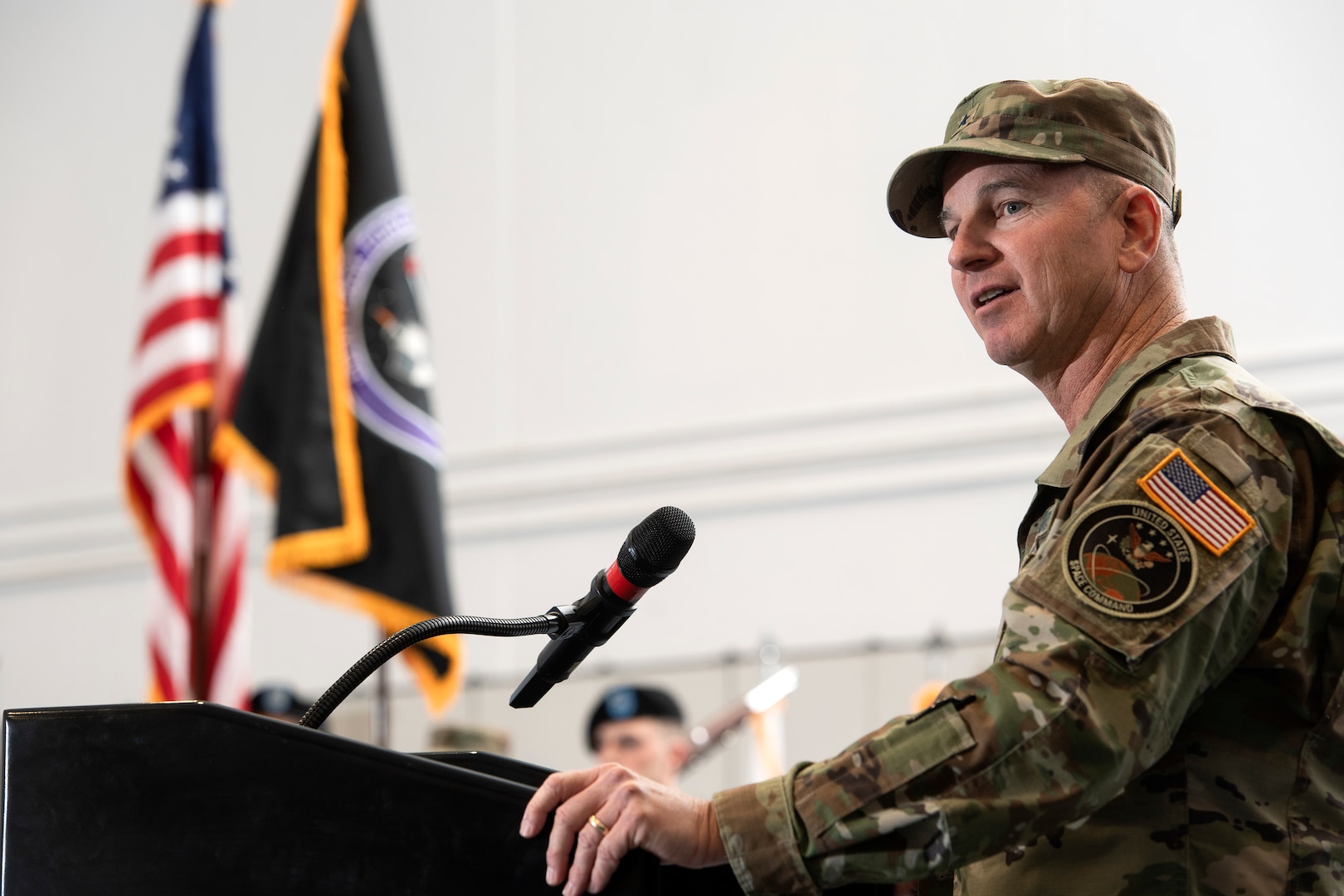 Man in military uniform speaking at podium