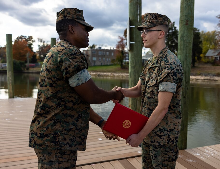 U.S. Marine Corps Cpl. Keegan Bailey, a combat graphics specialist, right, receives his promotion warrant from Capt. Michael Curtis, a Communications Strategy Operations officer, both with Security Battalion, during his promotion ceremony to corporal on Marine Corps Base Quantico, Virginia, Nov. 1, 2022. Promotion ceremonies are a significant achievement in a service member’s career and are a testament to their commitment, mastery of duties and skills, and leadership capabilities. Marines take on greater responsibilities as Non-Commissioned Officers after showing exemplary leadership skills. Bailey is a native of Friday Harbor, Washington and is a graduate of Friday Harbor High School on June 4, 2020. (U.S. Marine Corps photo by Lance Cpl. Joaquin Dela Torre)