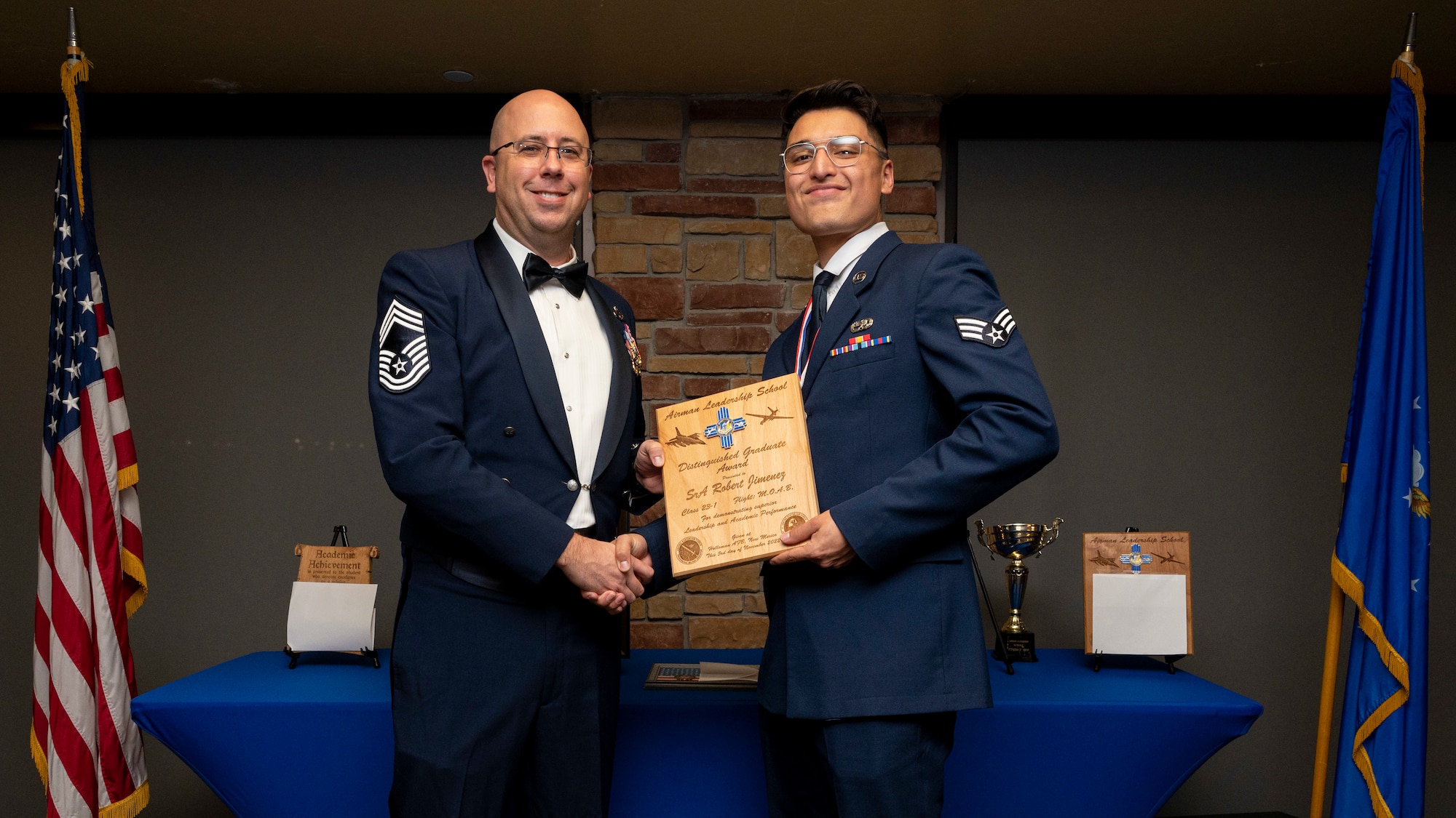 U.S. Air Force Senior Robert Jimenez, right, accepts the Distinguished Graduate Award from Holloman Top III representative Chief Master Sgt. Benjamin Vanderpuy during an Airman Leadership School graduation at Holloman Air Force Base, New Mexico, Nov. 3, 2022.