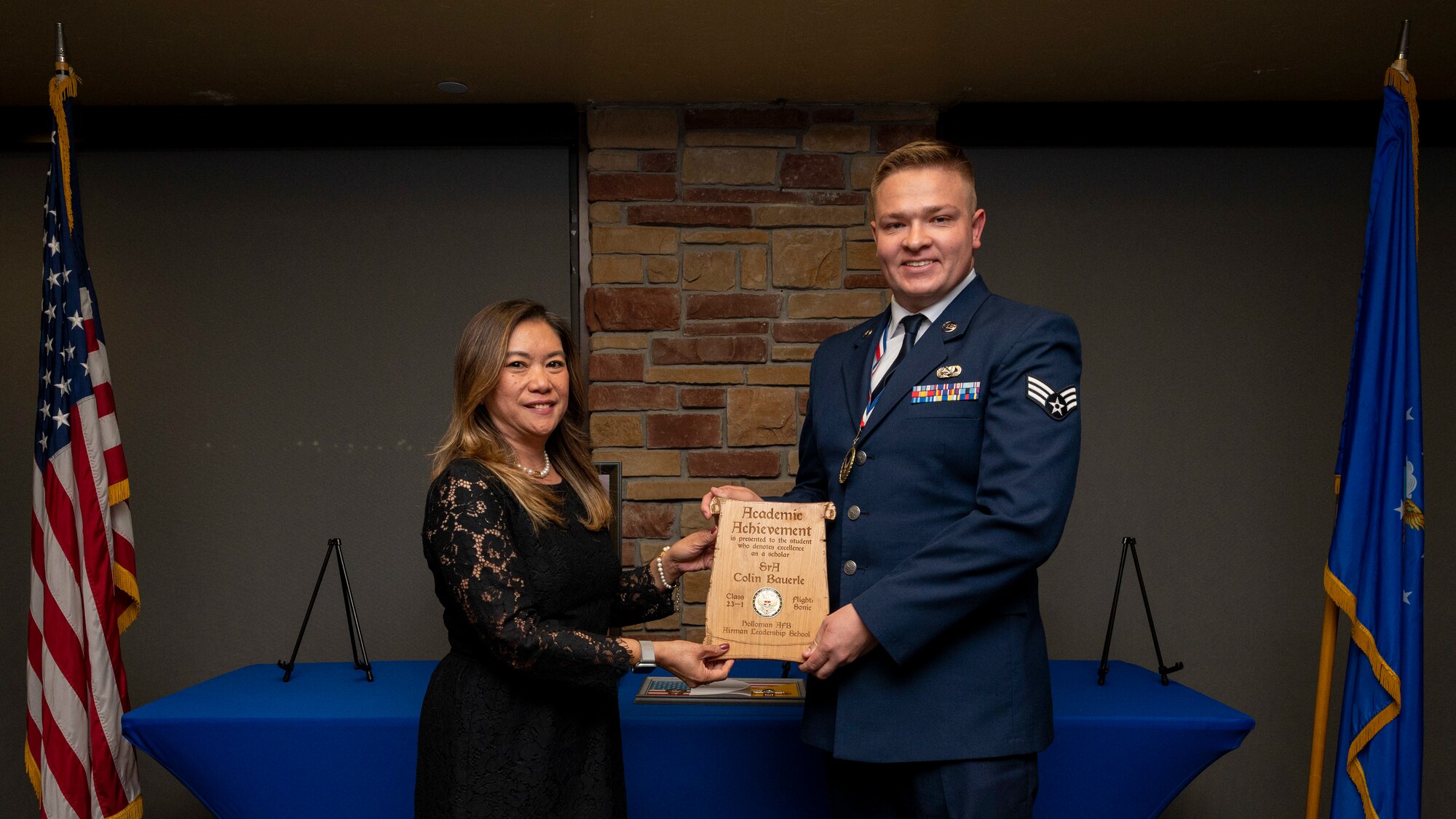 U.S. Air Force Senior Colin Bauerle, right, accepts the Academic Achievement Award from Laney Cooper, Otero Federal Credit Union representative, during an Airman Leadership School graduation at Holloman Air Force Base, New Mexico, Nov. 3, 2022.
