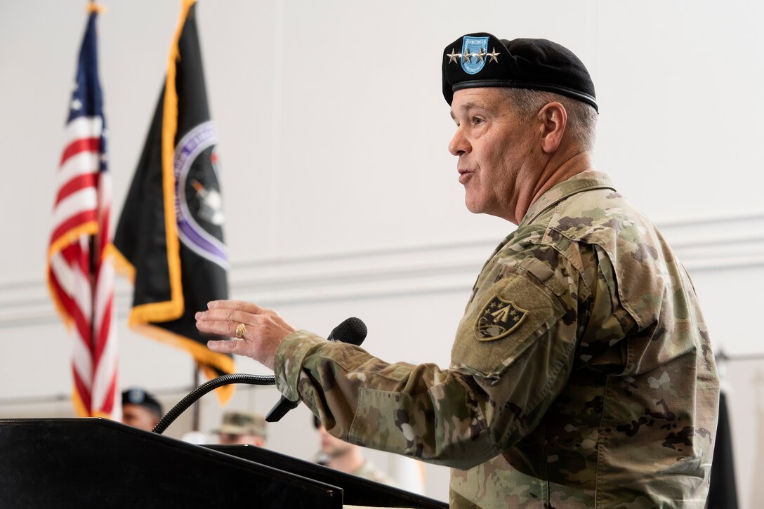 Man in military uniform speaking into microphone