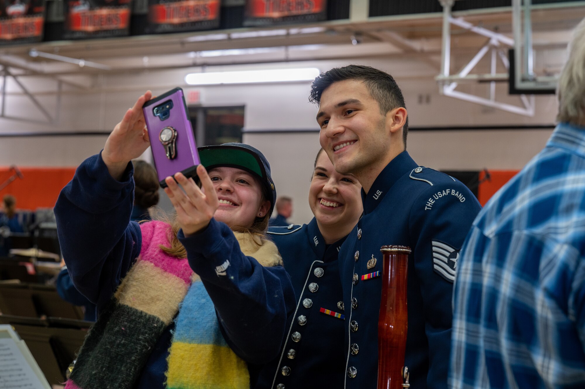 U.S. Air Force Tech. Sgts. Emily Foster and Isaac Sanabria pose for a selfie with an audience member after The United States Air Force Band’s Fall Tour concert at Battle Ground High School, Battle Ground, Wash., Oct. 24, 2022. The Band’s live performances attracted thousands of audience members from across the Pacific Northwest region. (U.S. Air Force photo by Kristen Wong)