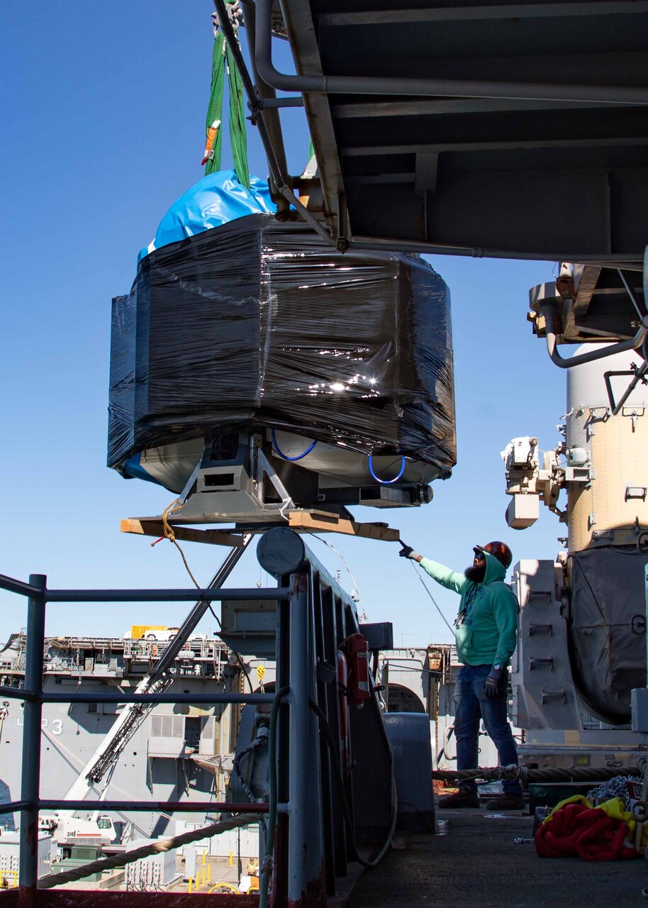 Kenya Latham, assigned to East Coast Repair, coordinates the on load of a three dimensional printer aboard the Wasp-class amphibious assault ship USS Bataan (LHD 5), Oct. 19, 2022.