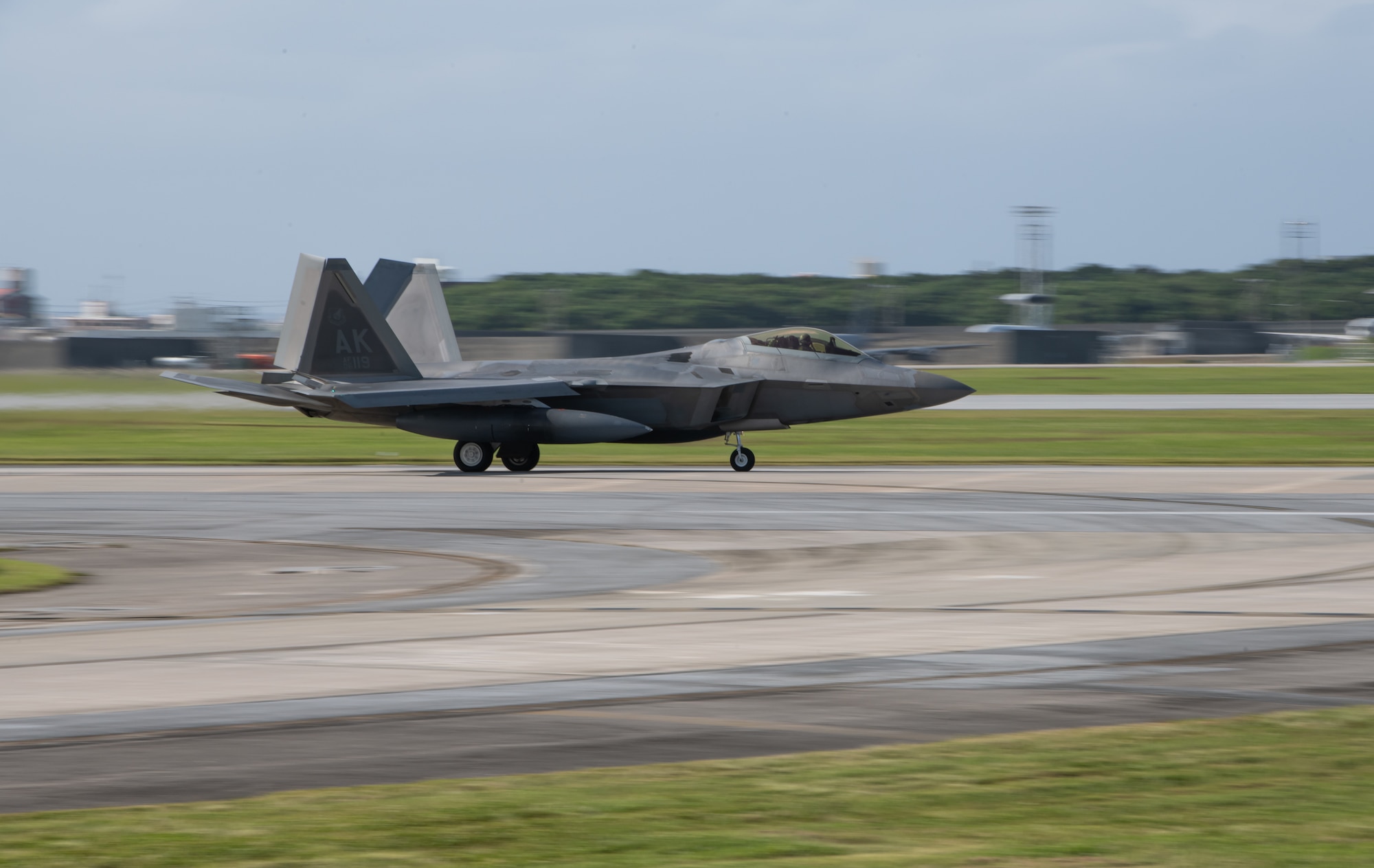 An F-22 Raptor lands on a runway.