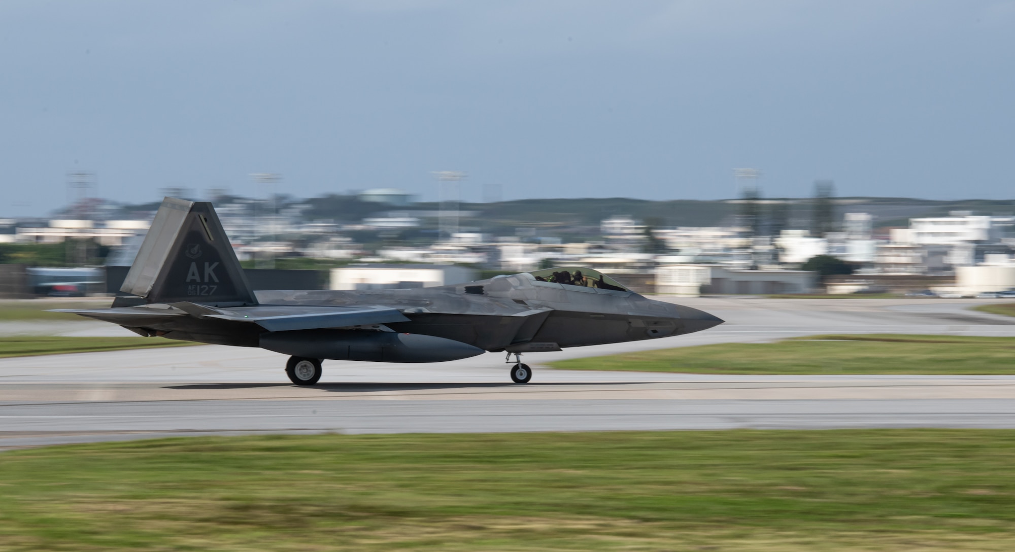 An F-22 Raptor lands on a runway.