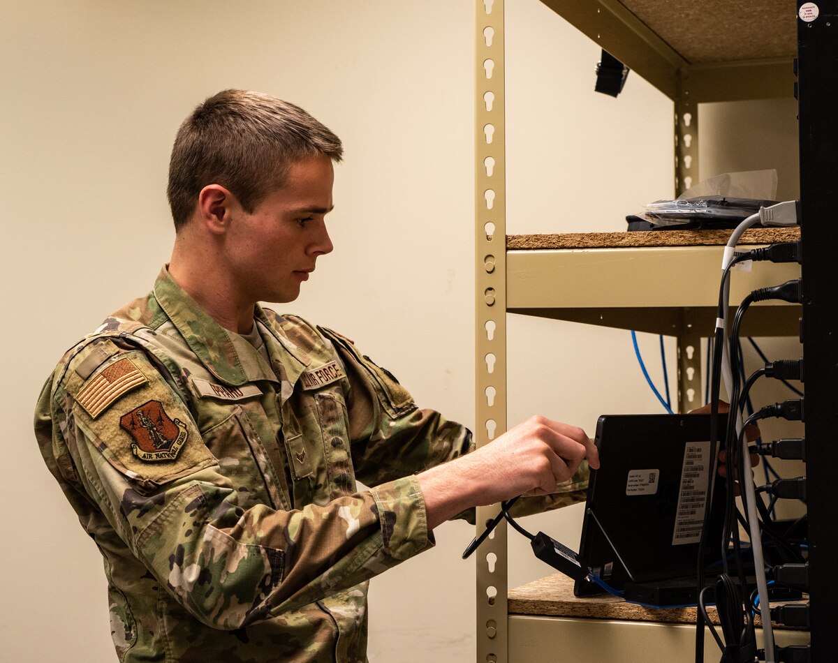 U.S. Air National Guard Airman 1st Class Carson Eppard, system administrator, 114th Fighter Wing, plugs in a tablet at Joe Foss Field, South Dakota, Nov. 6, 2022.