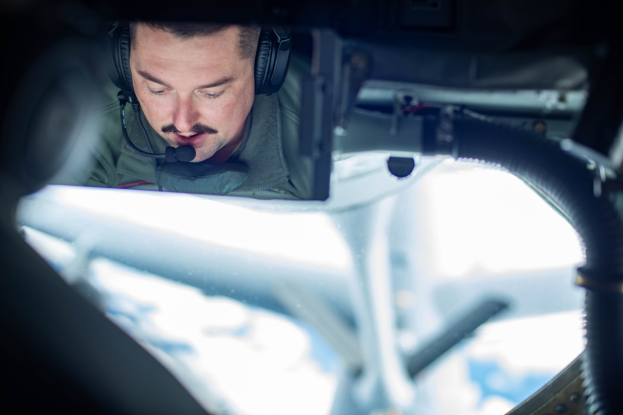 U.S. Air Force Staff Sgt. Tyler Espinoza, 909th Air Refueling Squadron boom operator, prepares to refuel an B-52 Stratofortress, assigned to the 5th Bomb Wing, over the Pacific, Oct. 27, 2022. Boom operators directly control the metal arm located in the rear of refueling aircraft, commonly known as the "boom," to refuel Ally aircraft in mid-air. (U.S. Air Force photo by Airman Alexis Redin)