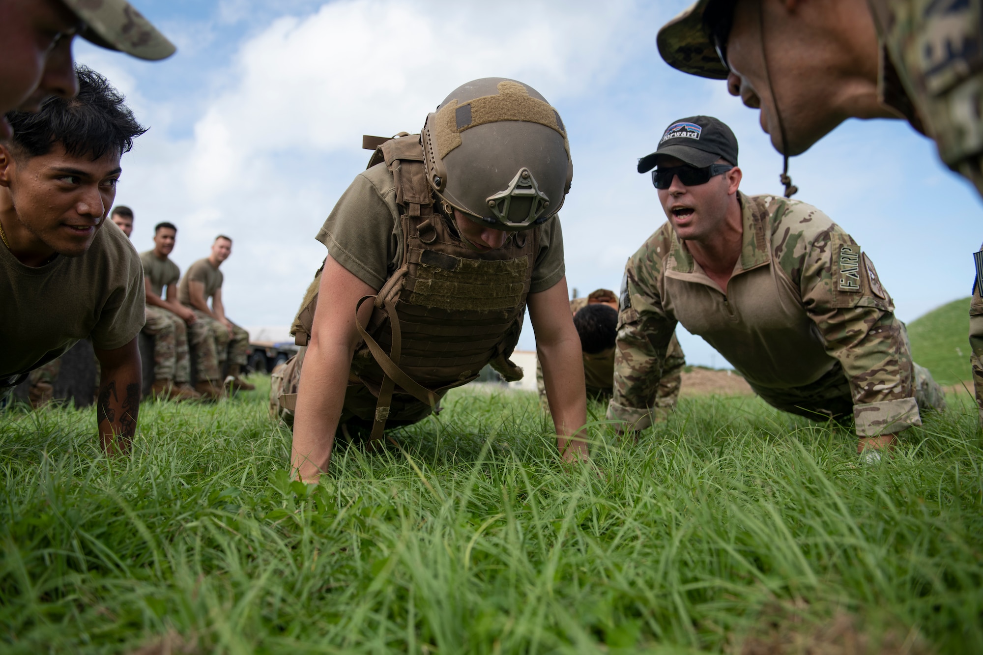Airman 1st Class Kaleb Gissendanner, 18th Logistics Readiness Squadron fuels distribution operator, does push-ups while Forward Area Refueling Point members and fellow competitors motivate him to finish during a FARP tryout event at Kadena Air Base, Japan, Oct. 21, 2022. The Airmen were tasked with conducting a timed FARP set-up and break-down, followed by a set of endurance exercises. (U.S. Air Force photo by Senior Airman Jessi Roth)