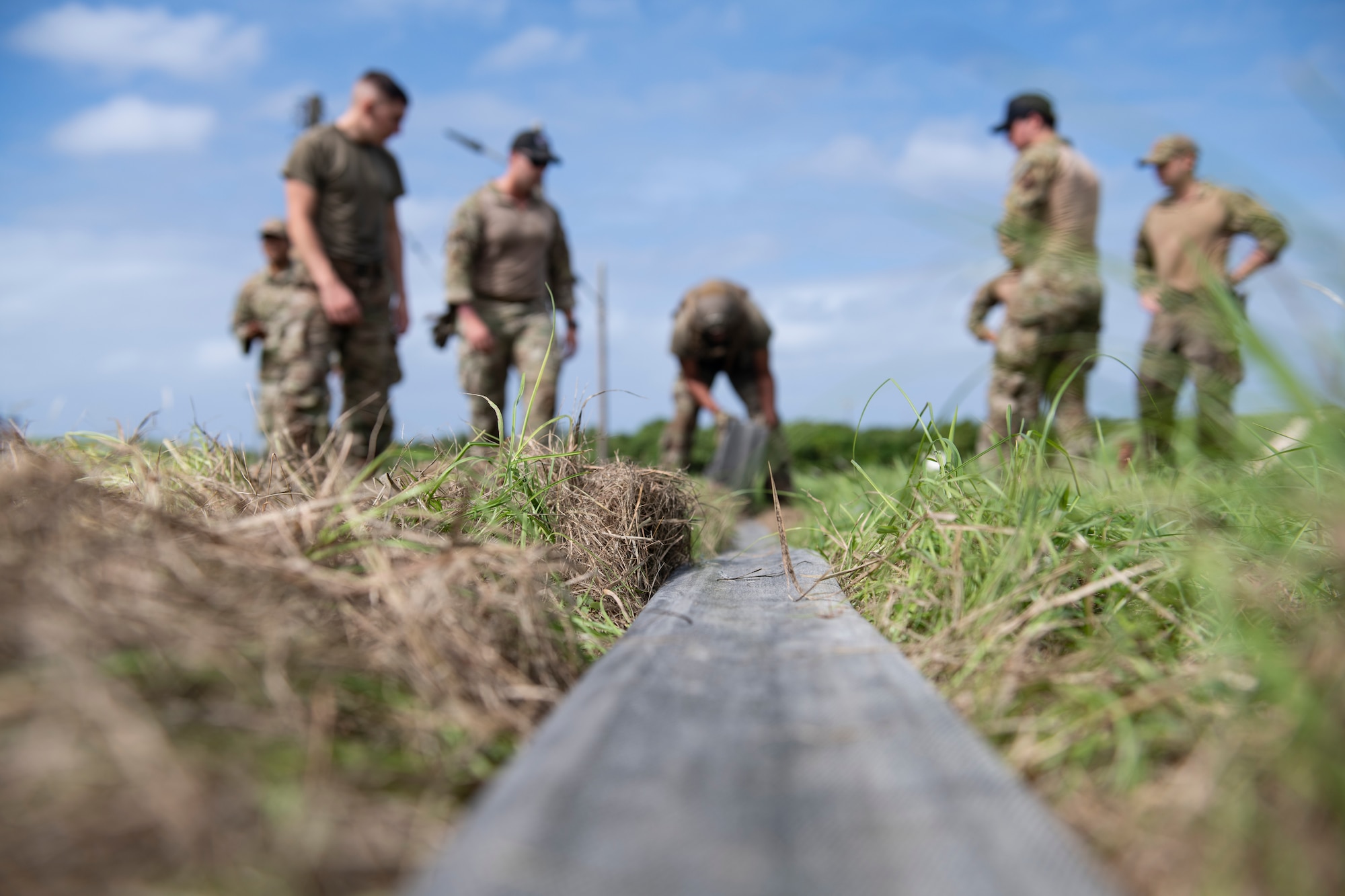 A U.S. Air Force Airman assigned to the 18th Logistics Readiness Squadron rolls a 100 foot section of hose during tryouts for the Forward Area Refueling Point team at Kadena Air Base, Japan, Oct. 21, 2022. Airmen were tasked with conducting a timed FARP set-up and break-down, followed by a set of endurance exercises. (U.S. Air Force photo by Senior Airman Jessi Roth)