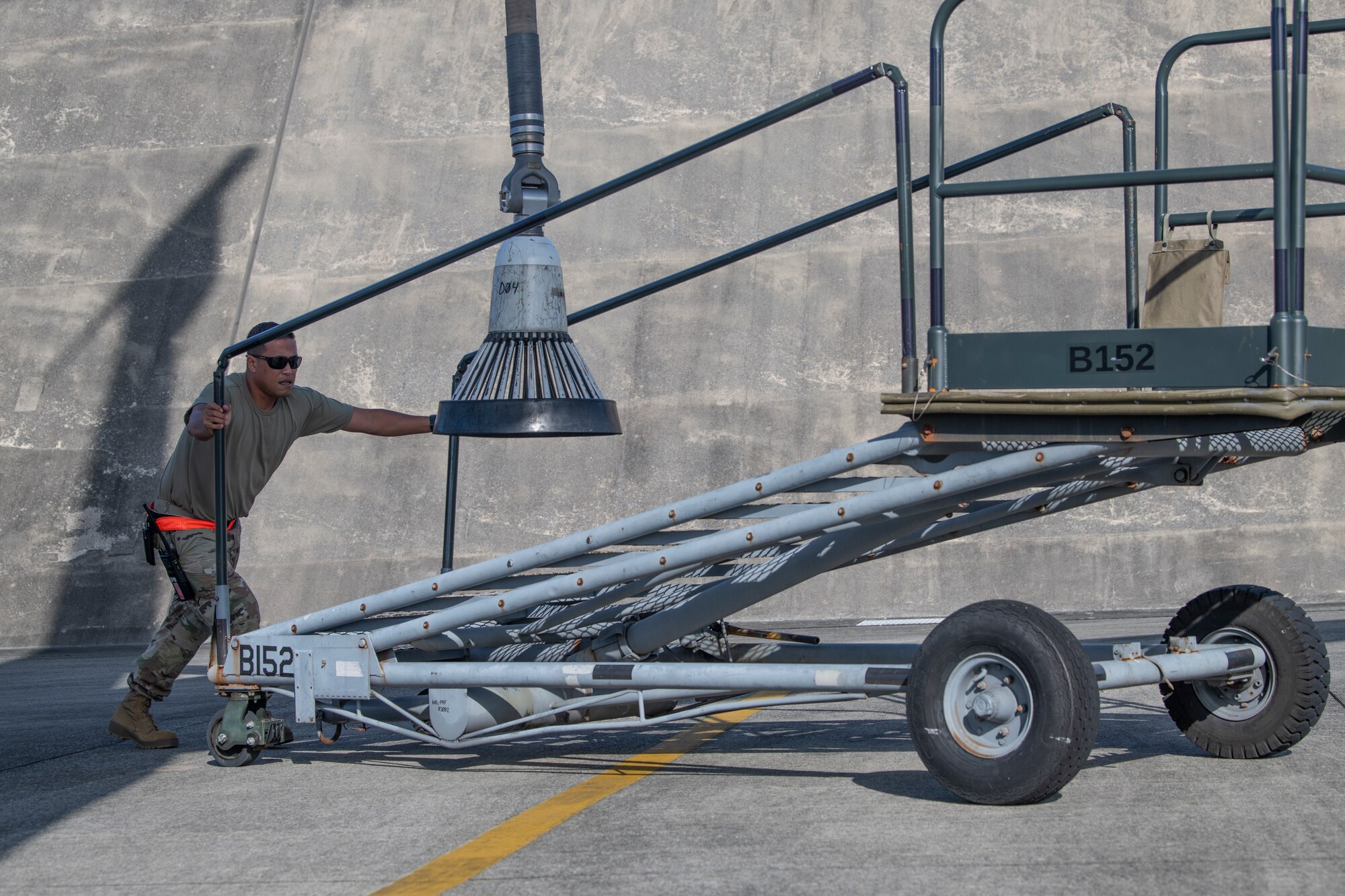 A crew chief assigned to the 909th Aircraft Maintenance Unit moves a staircase after securing the drogue to a KC-135 Stratotanker prior to a flight in support of a joint training exercise over the Pacific Ocean, Oct. 24, 2022. The drogue trails behind the tanker on a flexible hose. During aerial refueling, it connects with a retractable probe on the receiving aircraft to deliver fuel. (U.S. Air Force photo by Senior Airman Jessi Roth)