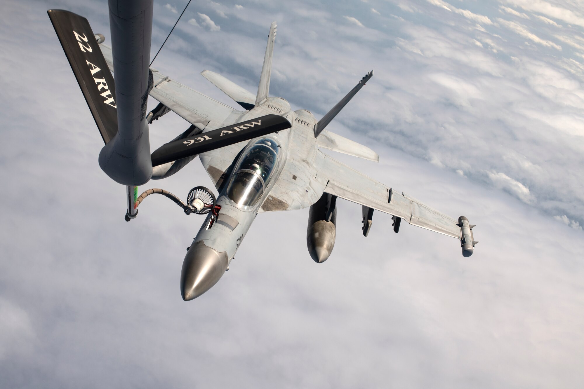 A U.S. Navy F/A-18 Super Hornet receives fuel from a KC-135 Stratotanker assigned to the 909th Air Refueling Squadron during a joint training exercise over the Pacific Ocean, Oct. 24, 2022. During the drogue-and-probe refueling method, a retractable probe from the receiving aircraft connects with the drogue, which trails behind the tanker aircraft via a hose attached to the flying boom. (U.S. Air Force photo by Senior Airman Jessi Roth)