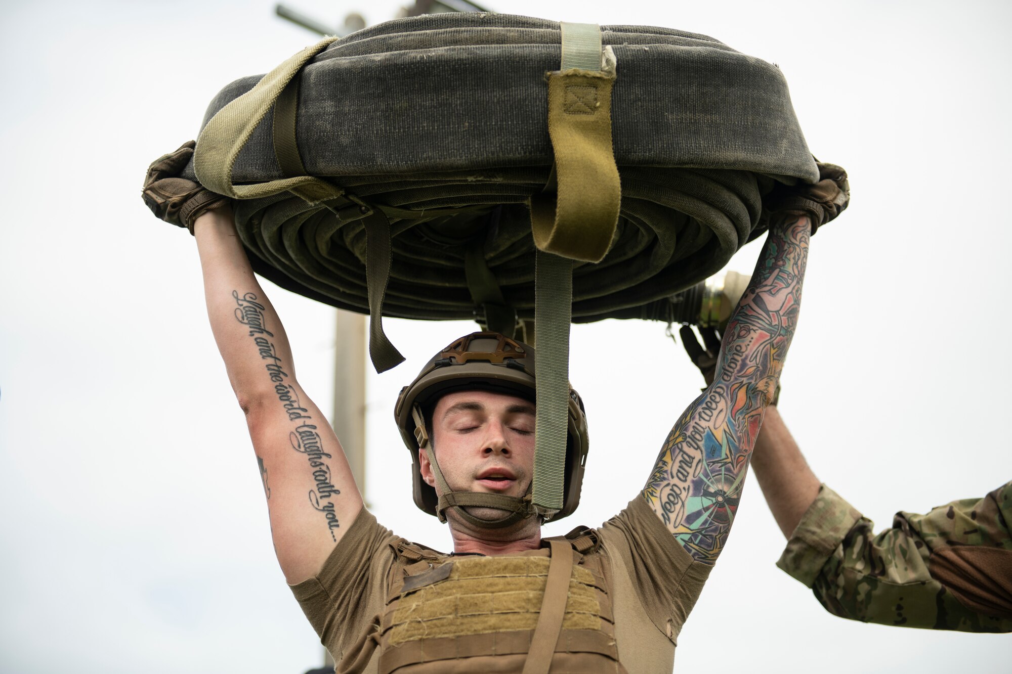U.S. Air Force Staff Sgt. Lucas Berg, 18th Logistics Readiness Squadron fuels training and support supervisor, holds a 100 pound hose bundle overhead during tryouts for the Forward Area Refueling Point team at Kadena Air Base, Japan, Oct. 21, 2022. The Airmen were tasked with conducting a timed FARP set-up and break-down, followed by a set of endurance exercises. (U.S. Air Force photo by Senior Airman Jessi Roth)