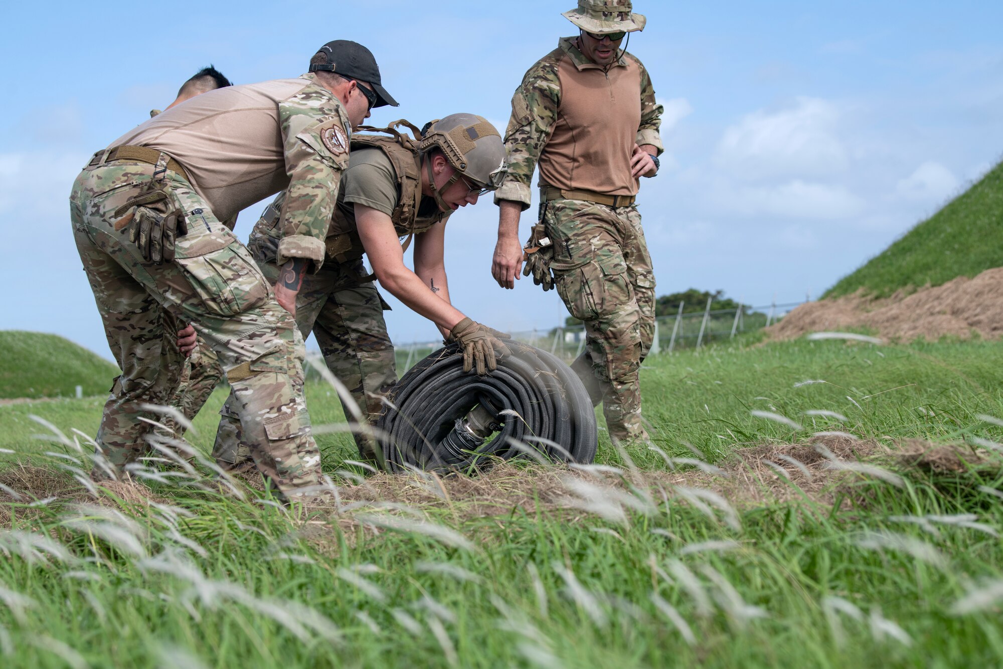 Airman 1st Class Logan Weins, 18th Logistics Readiness Squadron fuels distribution operator, rolls a 100 foot section of hose during tryouts for the Forward Area Refueling Point team at Kadena Air Base, Japan, Oct. 21, 2022. Airmen selected to join the team will receive further training to prepare them for special operations at night and in austere environments in support of forward-deployed combat units. (U.S. Air Force photo by Senior Airman Jessi Roth)