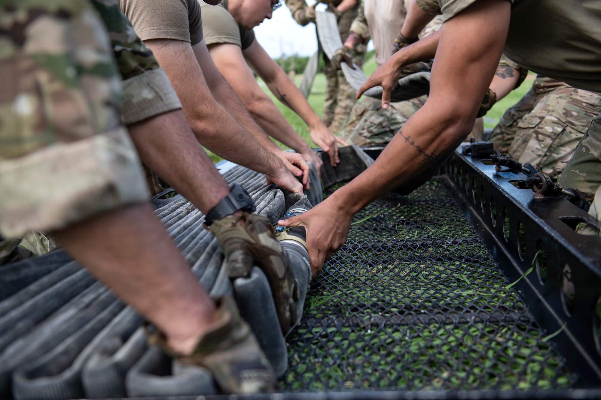 U.S. Air Force Airmen assigned to the 18th Logistics Readiness Squadron ready a 300 foot hose for the next competitor during tryouts for the Forward Area Refueling Point team at Kadena Air Base, Japan, Oct. 21, 2022. The tryouts enabled current FARP members to identify the most mentally and physically capable Airmen to be a part of the team. (U.S. Air Force photo by Senior Airman Jessi Roth)