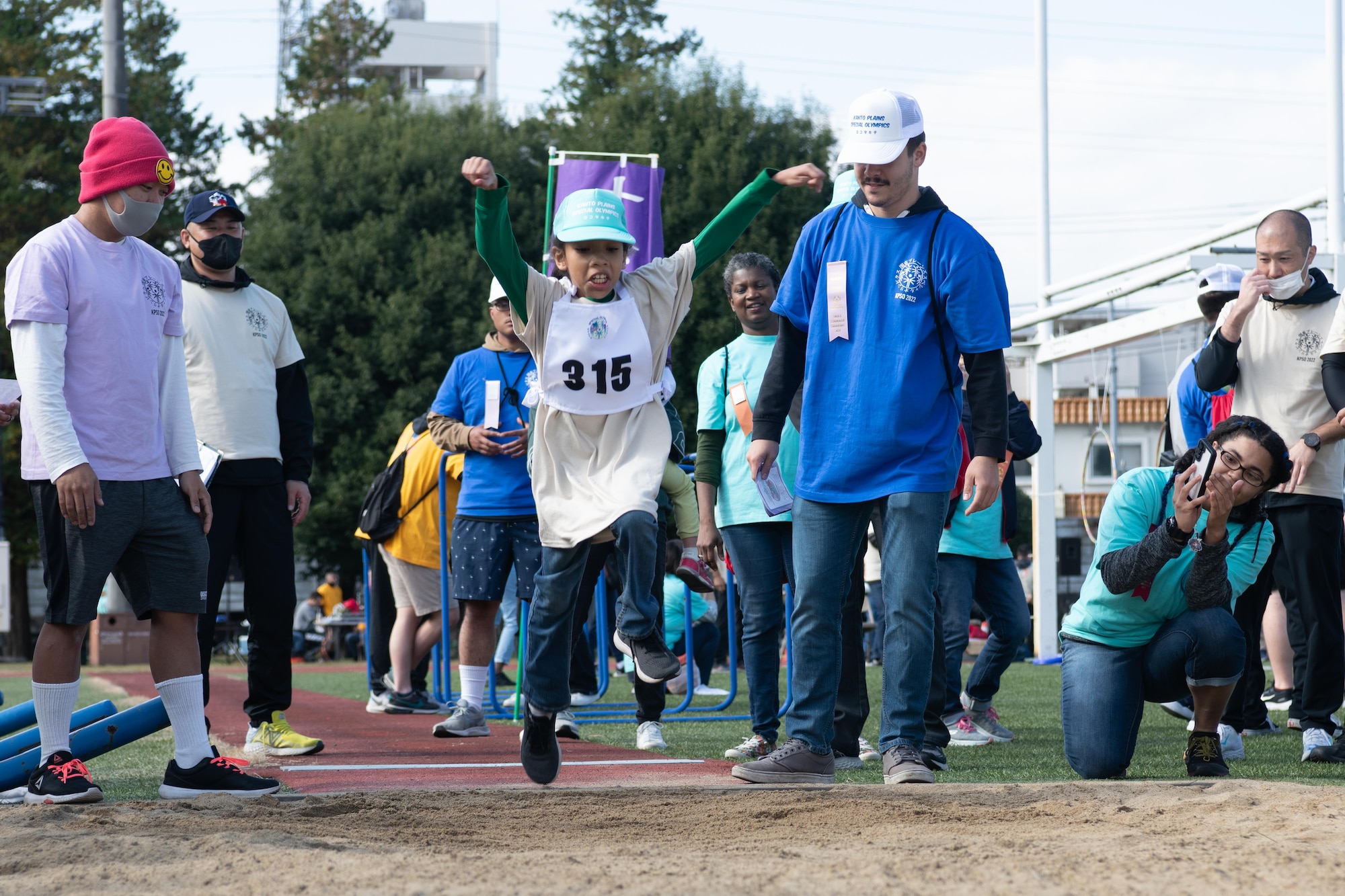 A Special Olympic youth athlete competes in the long jump.