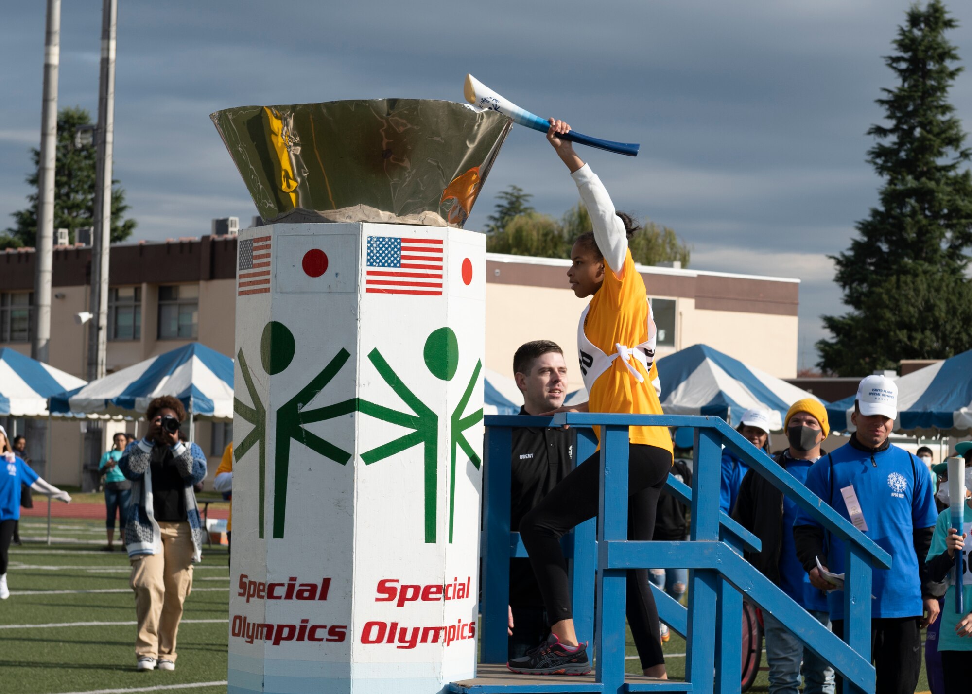 A Special Olympic athlete lights a mock torch