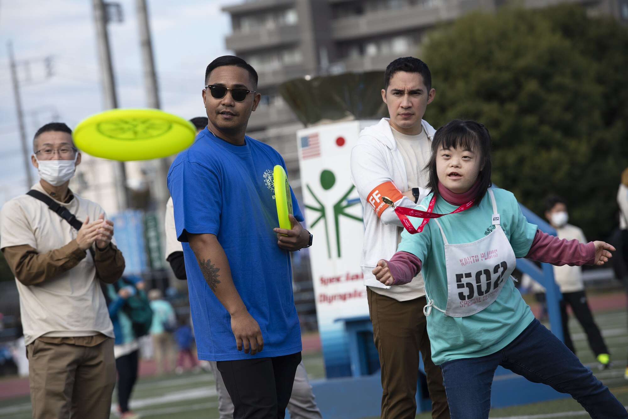 A Special Olympics youth athlete throws a frisbee.