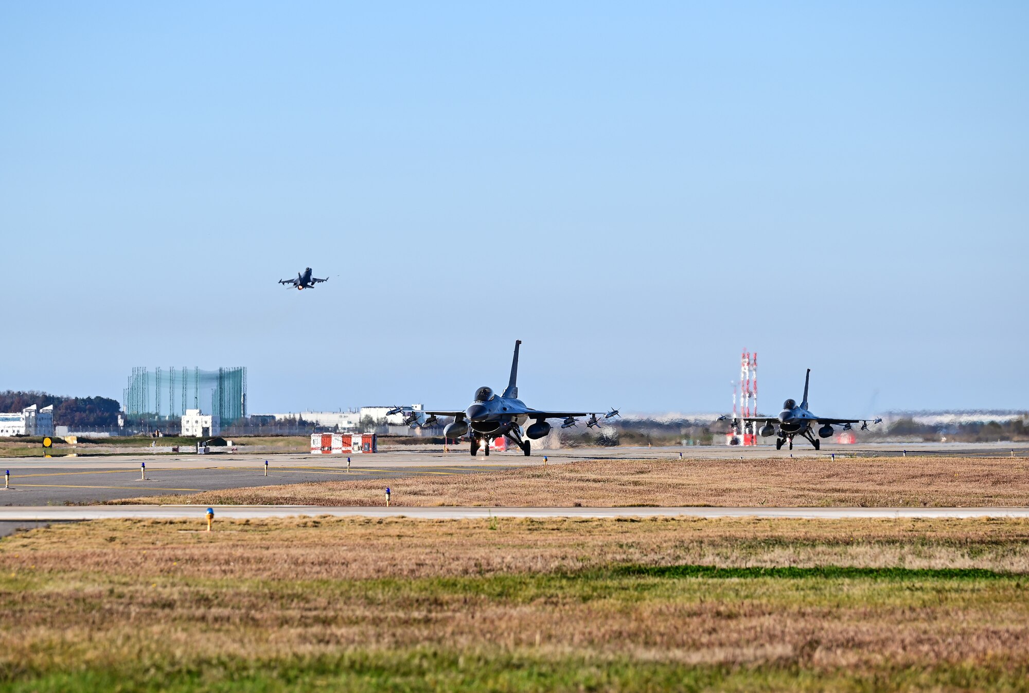 Two Republic of Korea Air Force F-16 Fighting Falcons with the 38th Fighter Group, taxi as a U.S. Air Force F-16 takes off at Kunsan Air Base, Republic of Korea, Nov. 2, 2022. Combined flying training events like this are intended to sharpen bilateral operations and strengthen the ROK-U.S. alliance. (U.S. Air Force photo by Staff Sgt. Sadie Colbert)