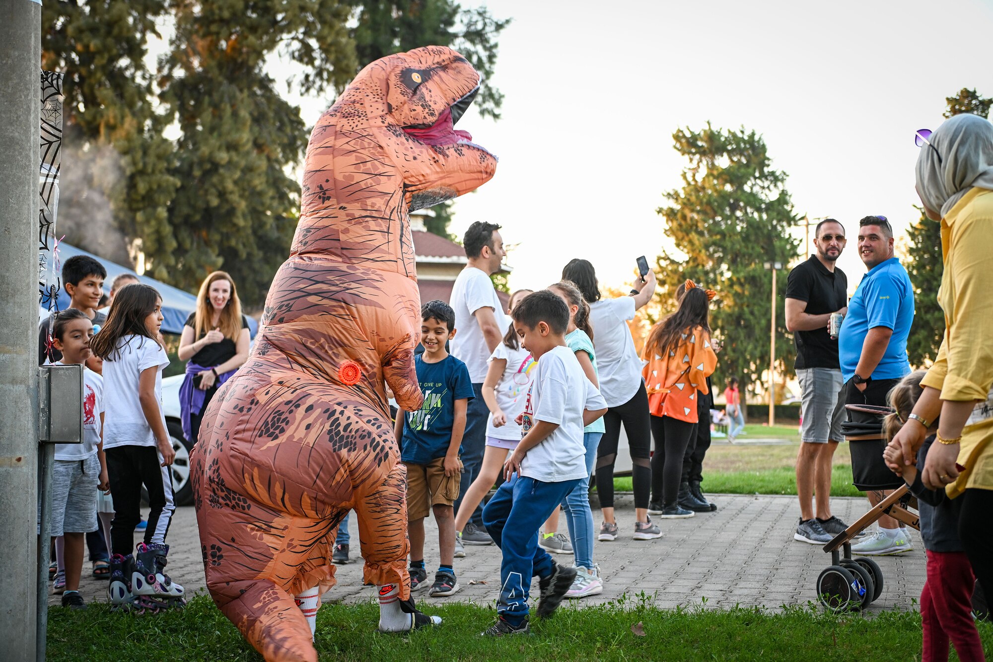 Maj. Tarah Cotton, 39th Comptroller Squadron commander, plays with Turkish children in a T-rex costume during the Trunk or Treat event at Incirlik Air Base, Turkey, Oct. 29, 2022.