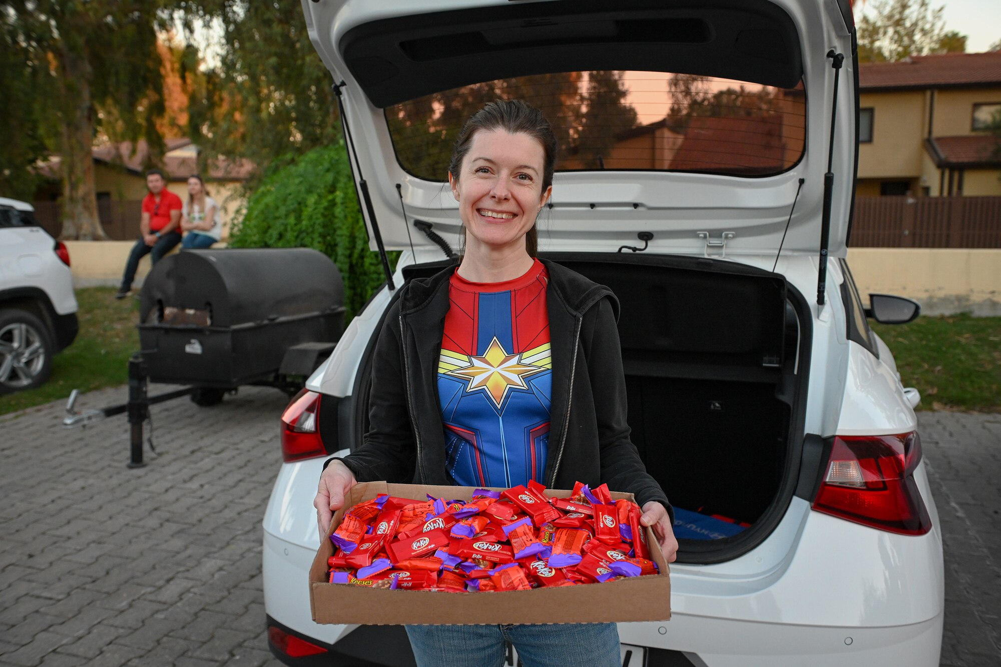 Capt. Debbie Giles, a chaplain assigned to the 39th Air Base Wing, poses for a photo with candy during the Trunk or Treat event at Incirlik Air Base, Turkey, Oct. 29, 2022.
