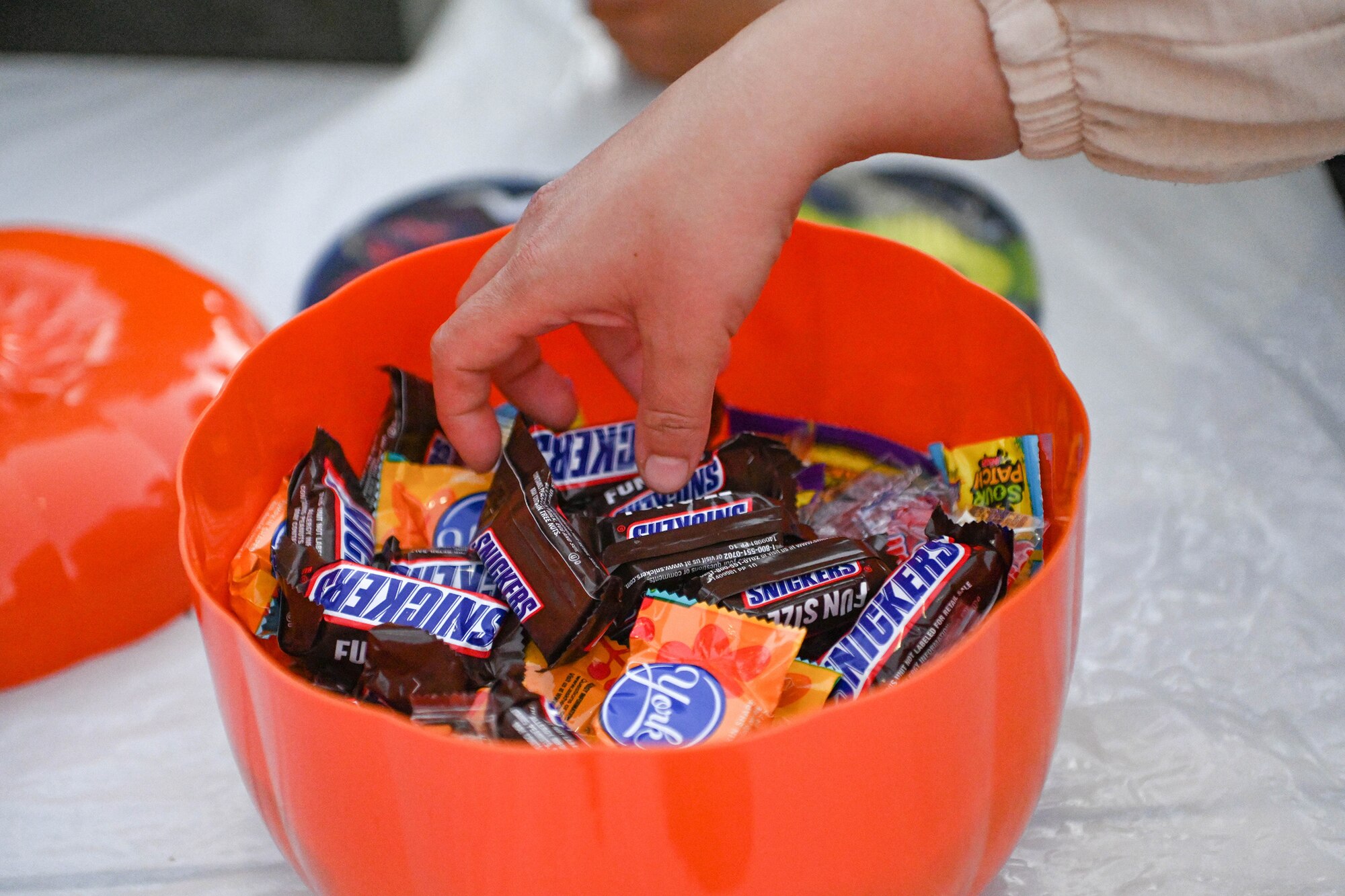 A Turkish child reaches into a bowl of candy during the Trunk or Treat event at Incirlik Air Base, Turkey, Oct. 29, 2022.